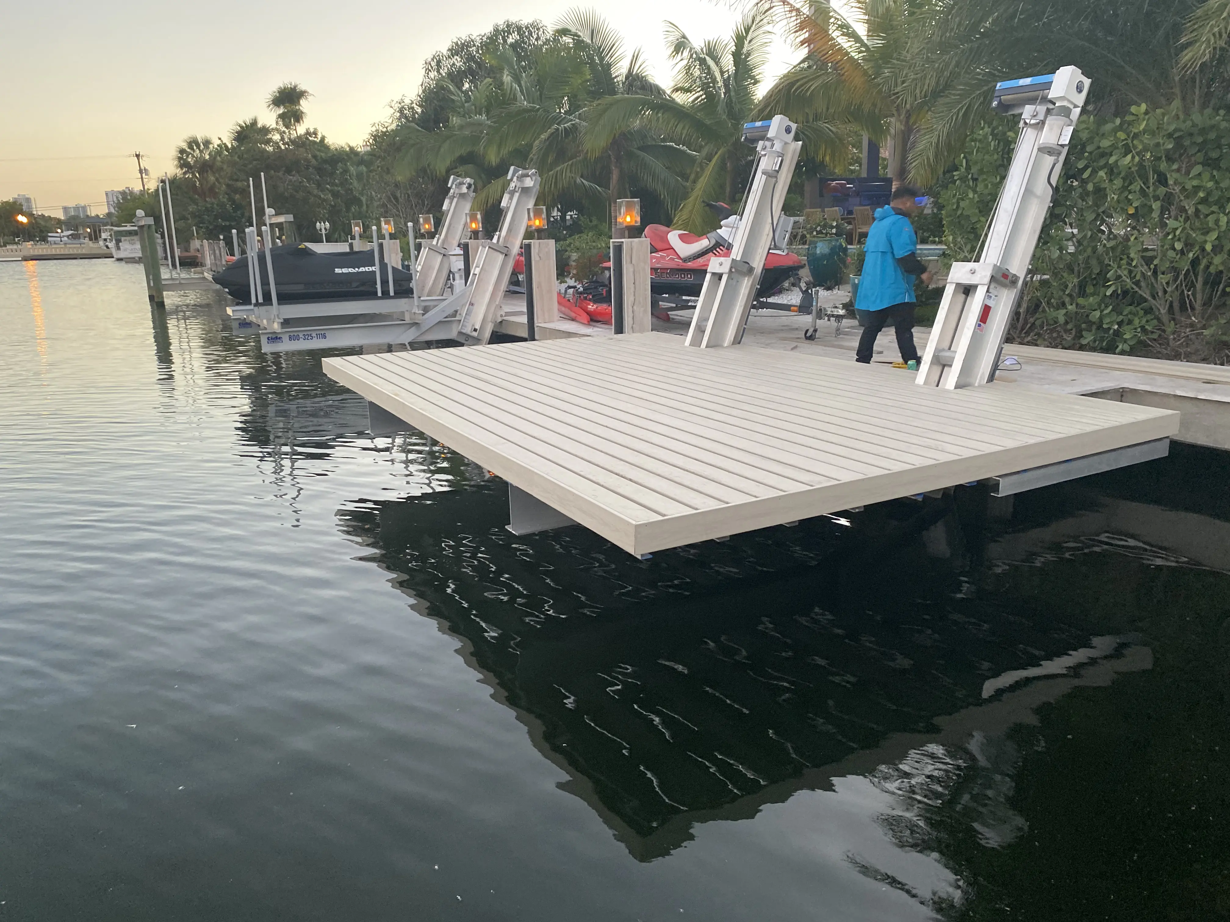 Jet ski lifts on a custom platform with composite decking on a South Florida canal, installed by Boat Lift Installers